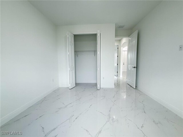 2703 42nd St SW, Lehigh Acres, FL 33976 - unfurnished bedroom with baseboards and light marble finish floors