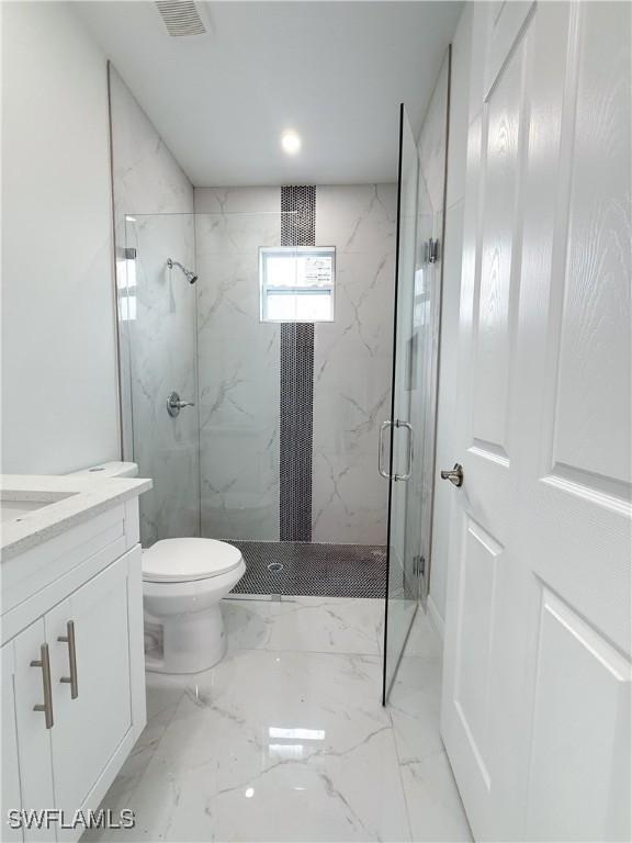 2703 42nd St SW, Lehigh Acres, FL 33976 - full bath with marble tiled floors, a marble finish shower, toilet, and vanity