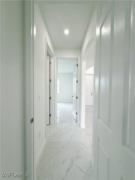 2703 42nd St SW, Lehigh Acres, FL 33976 - corridor featuring light marble finish floors, baseboards, arched walkways, and recessed lighting