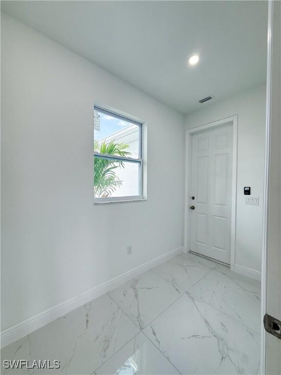 2703 42nd St SW, Lehigh Acres, FL 33976 - unfurnished room with baseboards, recessed lighting, and light marble finish flooring