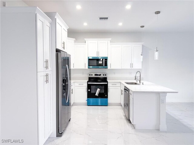 2703 42nd St SW, Lehigh Acres, FL 33976 - kitchen with stainless steel appliances, a sink, a peninsula, light marble finish floors, and light countertops
