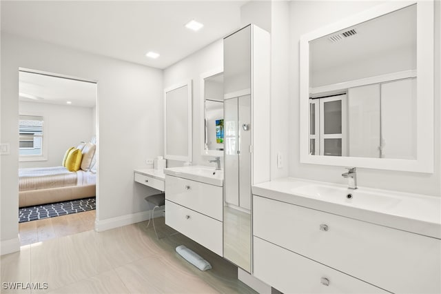 360 10th Ave S Unit B200, Naples, FL 34102 - ensuite bathroom featuring visible vents, two vanities, a sink, baseboards, and ensuite bath