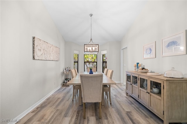 1904 Timberline Dr, Naples, FL 34109 - dining space featuring a chandelier, wood finished floors, baseboards, and high vaulted ceiling