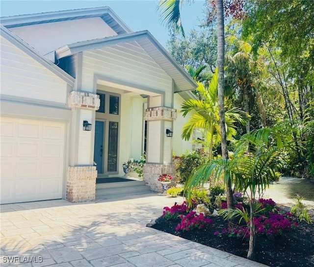 1904 Timberline Dr, Naples, FL 34109 - entrance to property featuring a garage, driveway, and brick siding