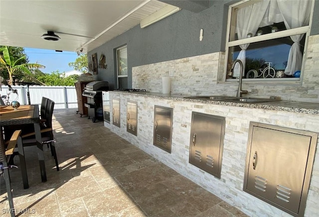 view of patio with a sink, an outdoor kitchen, and outdoor dining area