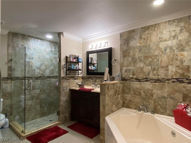 bathroom with tile walls, ornamental molding, a garden tub, vanity, and a shower stall