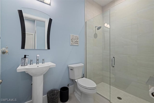 full bathroom with baseboards, a shower stall, and toilet