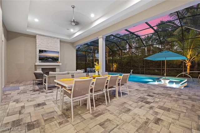 view of patio with outdoor dining area, a pool with connected hot tub, and a fireplace