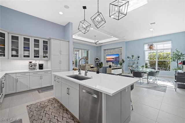 kitchen with stainless steel dishwasher, visible vents, light tile patterned flooring, light countertops, and a sink