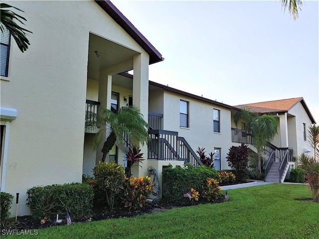 9265 Lake Park Dr Unit 201, Fort Myers, FL 33919 - exterior space featuring stairway, a yard, and stucco siding