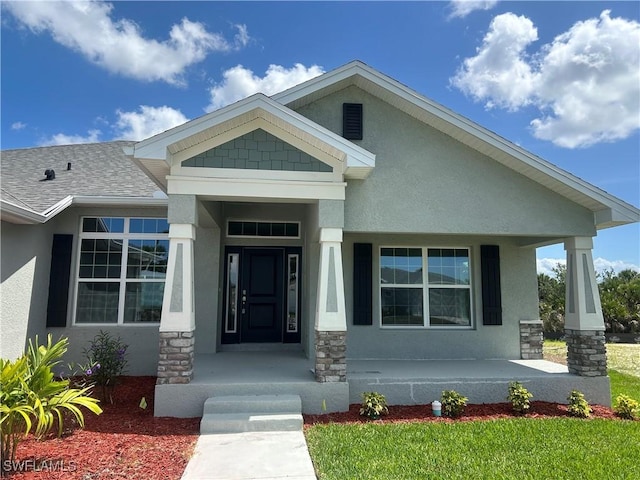 411 Paramaribo St, Punta Gorda, FL 33983 - property entrance with covered porch, stucco siding, and stone siding