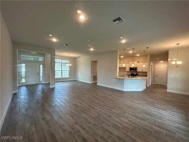 411 Paramaribo St, Punta Gorda, FL 33983 - unfurnished living room with a chandelier, dark wood finished floors, and recessed lighting