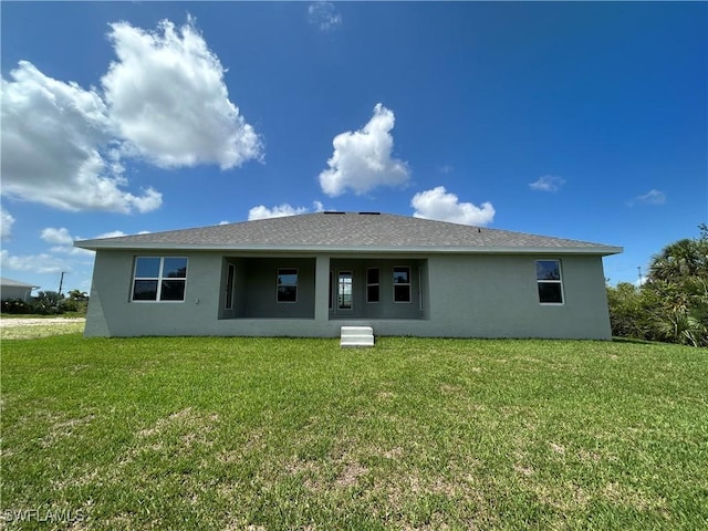 411 Paramaribo St, Punta Gorda, FL 33983 - back of house with stucco siding and a yard