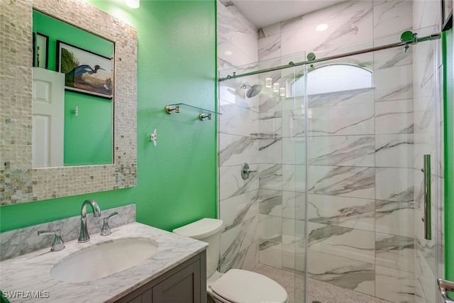 full bath featuring vanity, toilet, and a marble finish shower