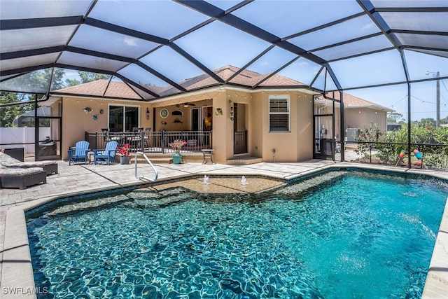 pool with a ceiling fan, glass enclosure, and a patio