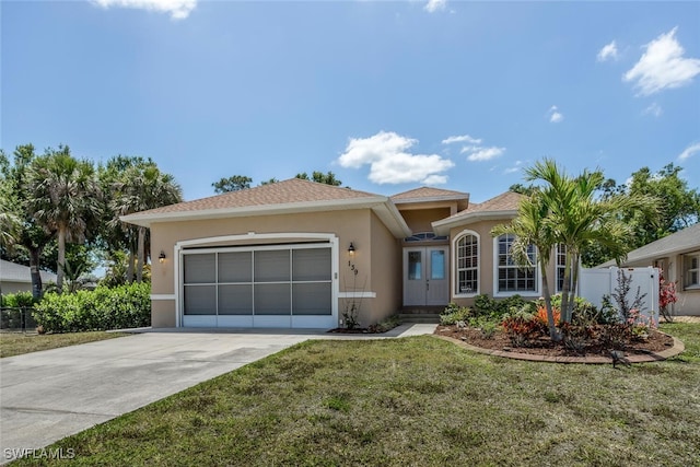view of front of home featuring driveway, stucco siding, a garage, and fence