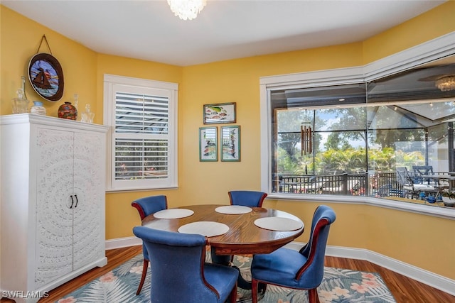 dining space featuring baseboards and wood finished floors