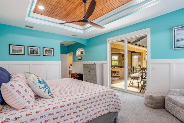 carpeted bedroom featuring wainscoting, visible vents, wooden ceiling, a tray ceiling, and access to exterior