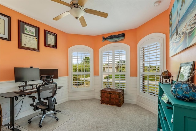 office area featuring carpet flooring, wainscoting, and ceiling fan
