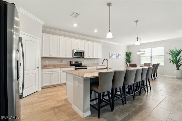 kitchen with crown molding, stainless steel appliances, visible vents, and a sink