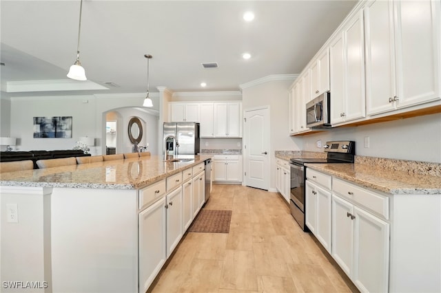 kitchen with recessed lighting, a sink, crown molding, arched walkways, and appliances with stainless steel finishes