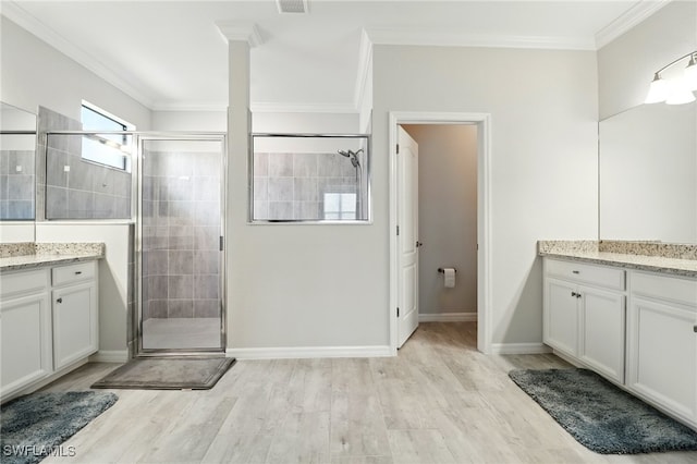 bathroom featuring vanity, wood finished floors, a shower stall, and ornamental molding