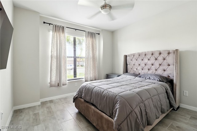 bedroom featuring light wood finished floors, baseboards, and a ceiling fan