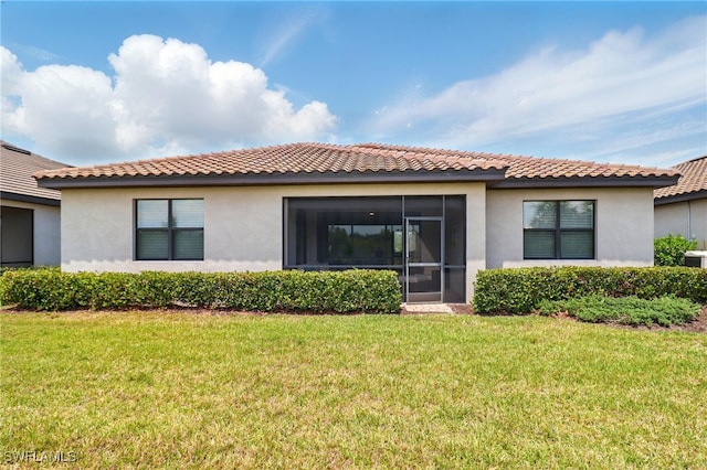 back of house featuring a lawn, stucco siding, and a tile roof