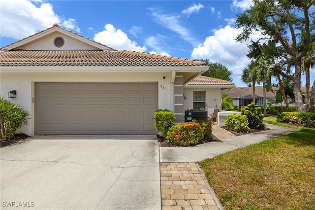 mediterranean / spanish home featuring stucco siding, a tile roof, and concrete driveway