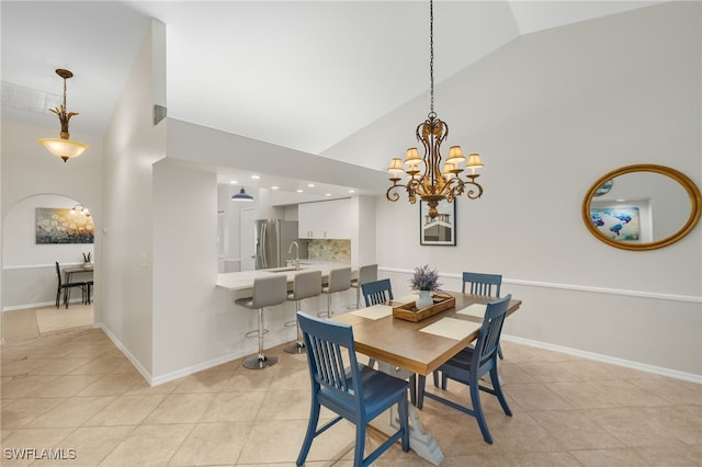 dining area with baseboards, light tile patterned floors, a notable chandelier, and high vaulted ceiling