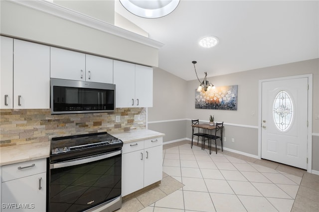 kitchen featuring electric range, stainless steel microwave, white cabinets, tasteful backsplash, and vaulted ceiling