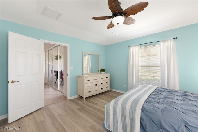 bedroom with visible vents, light wood finished floors, ceiling fan, and baseboards