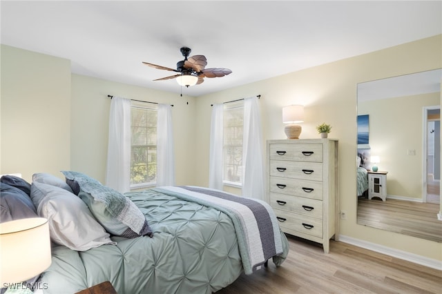 bedroom featuring baseboards, light wood finished floors, and ceiling fan