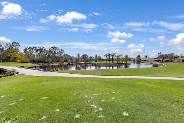 view of home's community featuring a lawn, view of golf course, and a water view