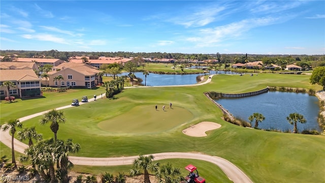 drone / aerial view featuring a water view, golf course view, and a residential view