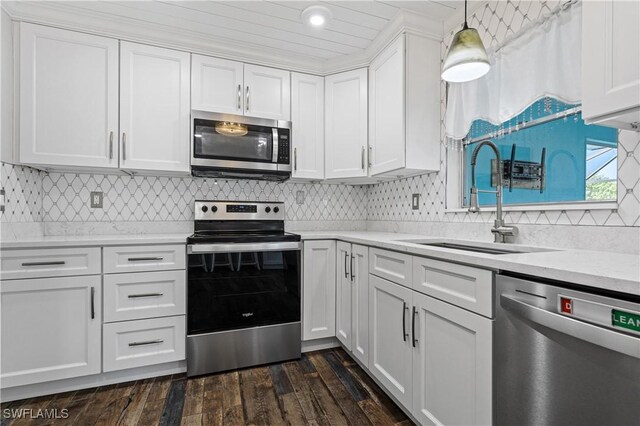 kitchen with appliances with stainless steel finishes, a sink, white cabinetry, light countertops, and recessed lighting