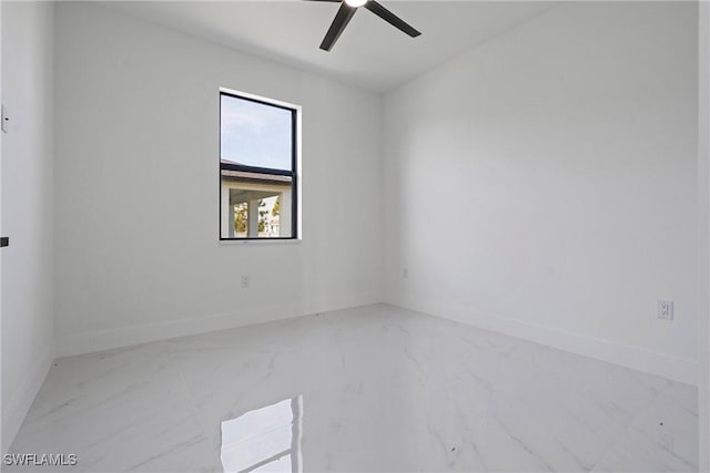 unfurnished room featuring baseboards, ceiling fan, and marble finish floor