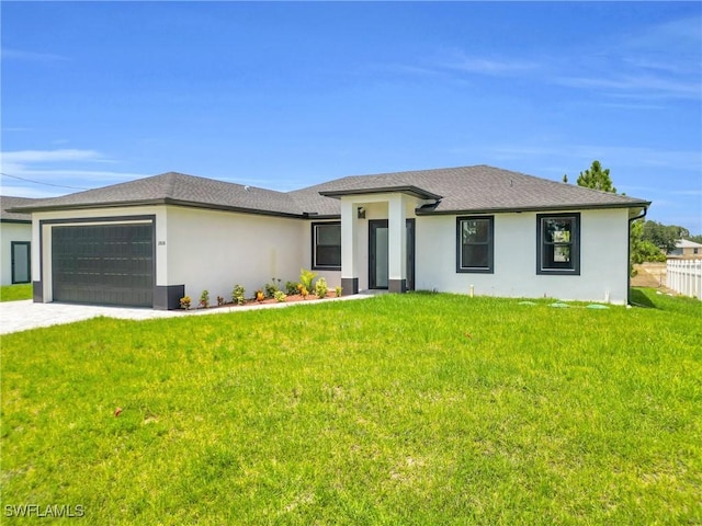 prairie-style home featuring stucco siding, driveway, a front lawn, and a garage