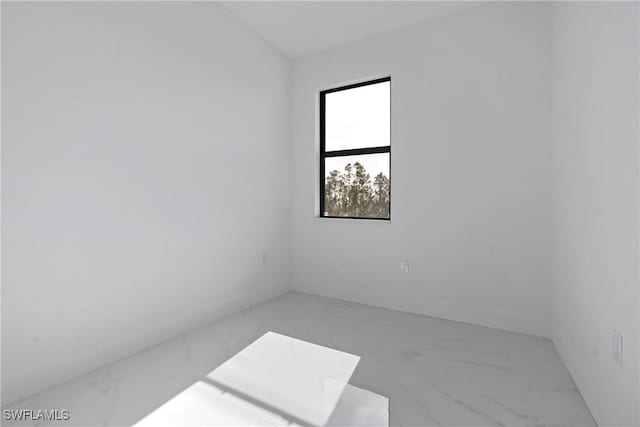 spare room featuring baseboards and marble finish floor