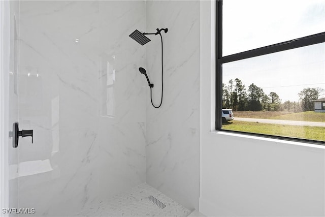 bathroom with a marble finish shower and a wealth of natural light
