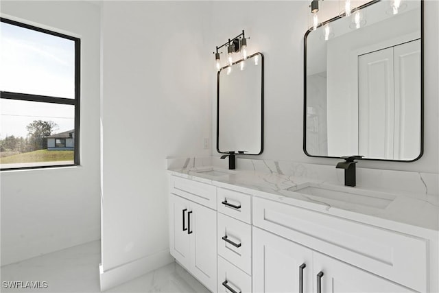 bathroom featuring double vanity, baseboards, a sink, and marble finish floor