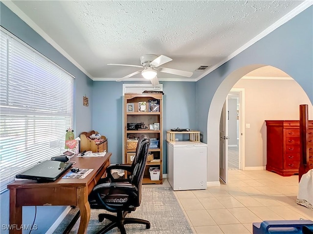 office featuring ornamental molding, ceiling fan, a textured ceiling, arched walkways, and light tile patterned floors