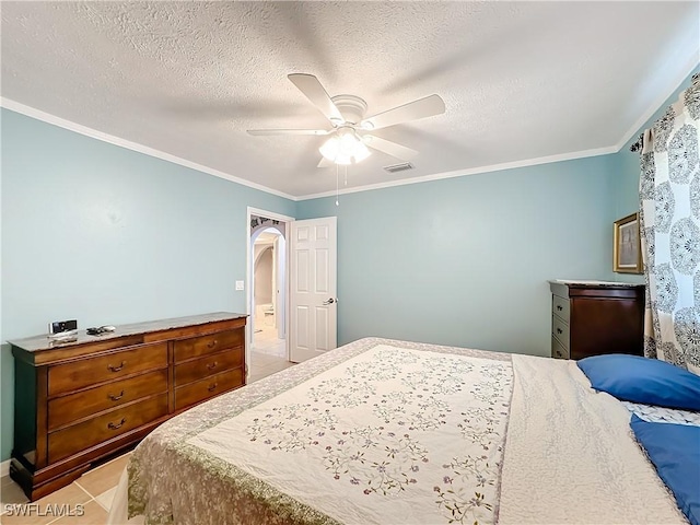 tiled bedroom featuring a ceiling fan, a textured ceiling, visible vents, crown molding, and arched walkways