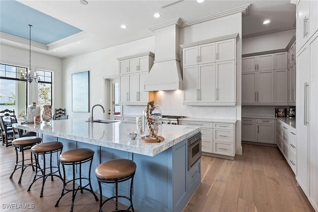 1247 Blue Hill Creek Dr, Marco Island, FL 34145 - kitchen with a sink, backsplash, crown molding, a breakfast bar area, and a large island with sink