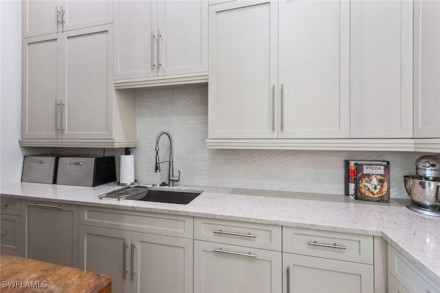 1247 Blue Hill Creek Dr, Marco Island, FL 34145 - kitchen with decorative backsplash, a sink, and light stone counters