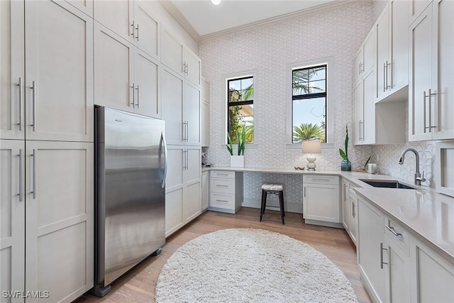 1247 Blue Hill Creek Dr, Marco Island, FL 34145 - kitchen with wallpapered walls, stainless steel refrigerator, a sink, ornamental molding, and light wood-style flooring