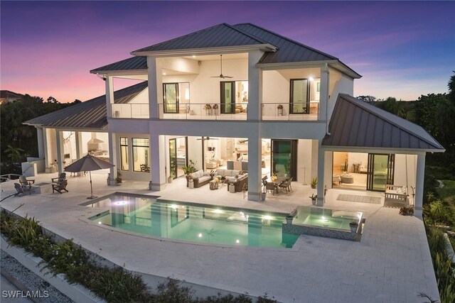 1247 Blue Hill Creek Dr, Marco Island, FL 34145 - back of house featuring a standing seam roof, a balcony, an outdoor hangout area, metal roof, and a patio area