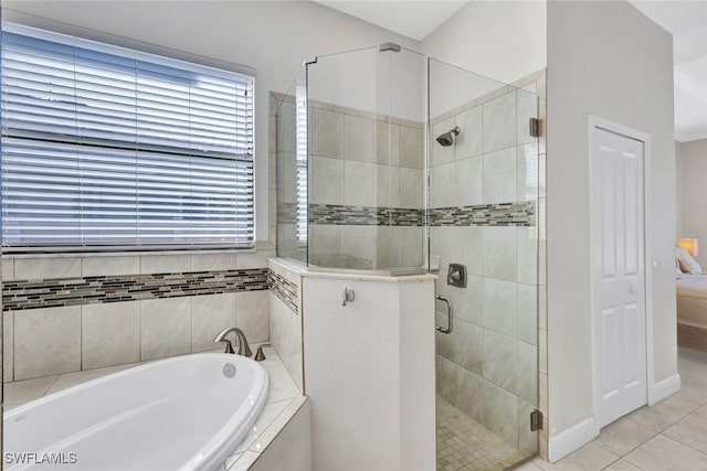 full bath featuring a garden tub, a shower stall, baseboards, and tile patterned flooring
