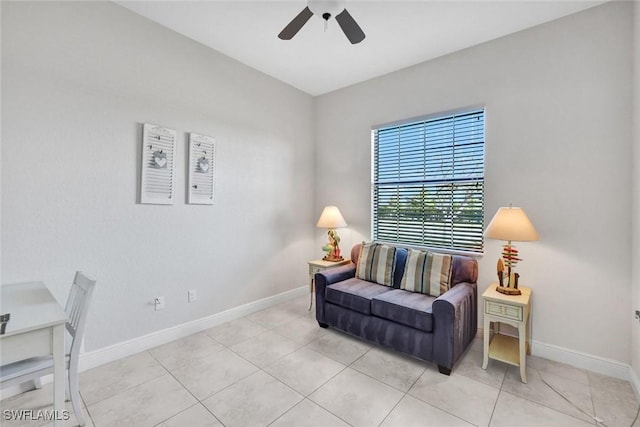 living area with ceiling fan, baseboards, and light tile patterned floors