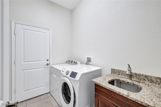 laundry area with independent washer and dryer and light tile patterned flooring